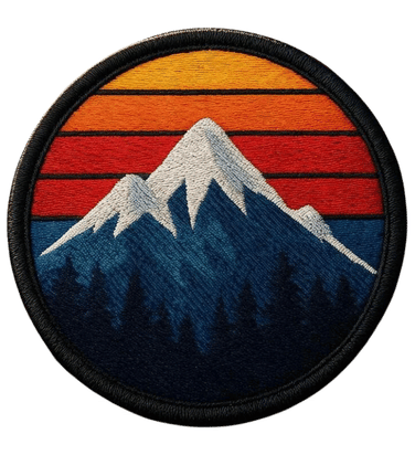 Round woven patch with a snow-capped mountain, pine forest, and striped orange sunset sky